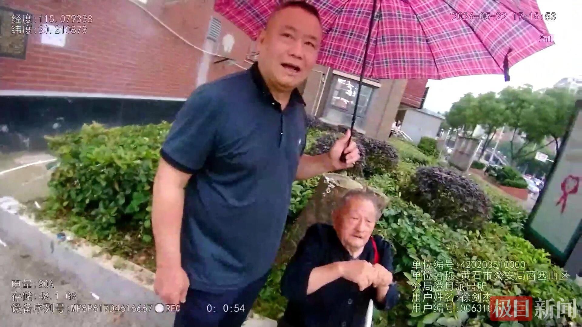 民警赶到时，一名自称是物业公司的男子守护一旁为老人撑伞