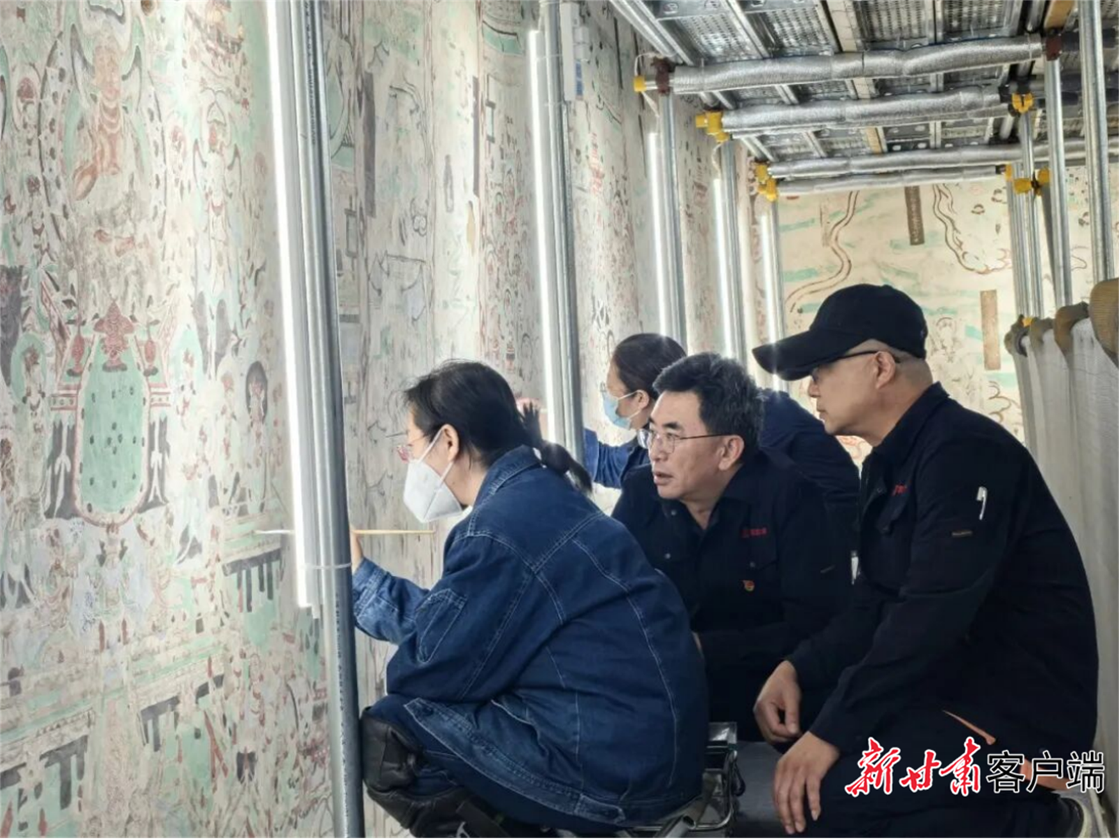 于宗仁(中)在莫高窟第55窟指导壁画保护修复。