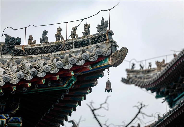 古建檐角上，屋脊神兽与风铃错落排布。