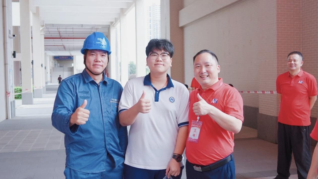图为：狮山供电所陈永辉与儿子及老师合影。