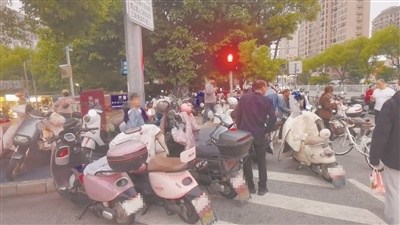 18点,青柠市集北门(正门)前道路,违停电动车影响其他车辆、行人正常通行。