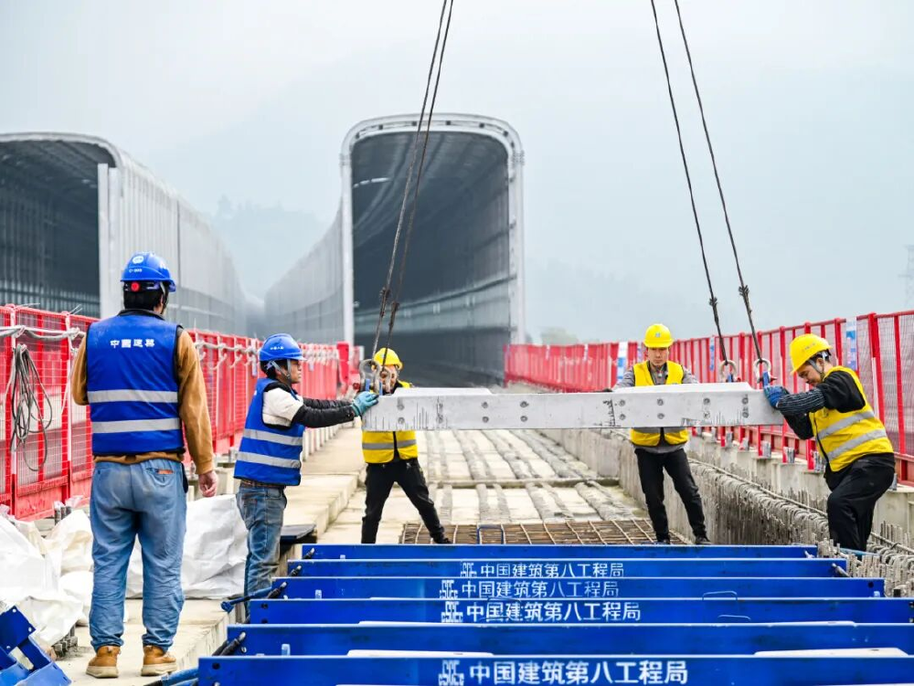 ▲工人合力完成预制轨道板安装。图源：中建八局轨道公司