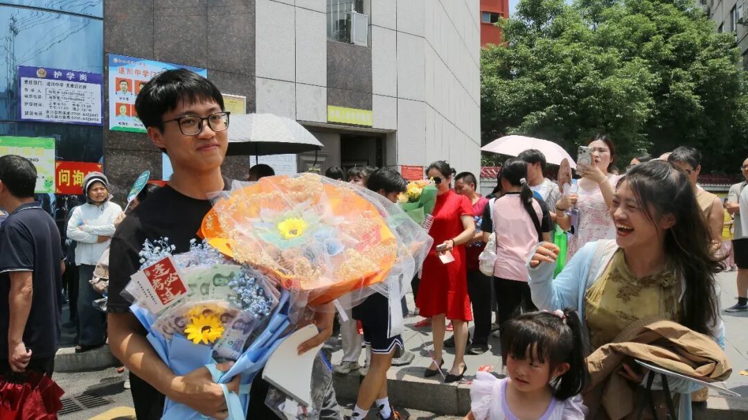 ▲遂川中学考点，考生步履轻快走出考场，家长与老师送上鲜花与祝福。（李建平 摄）