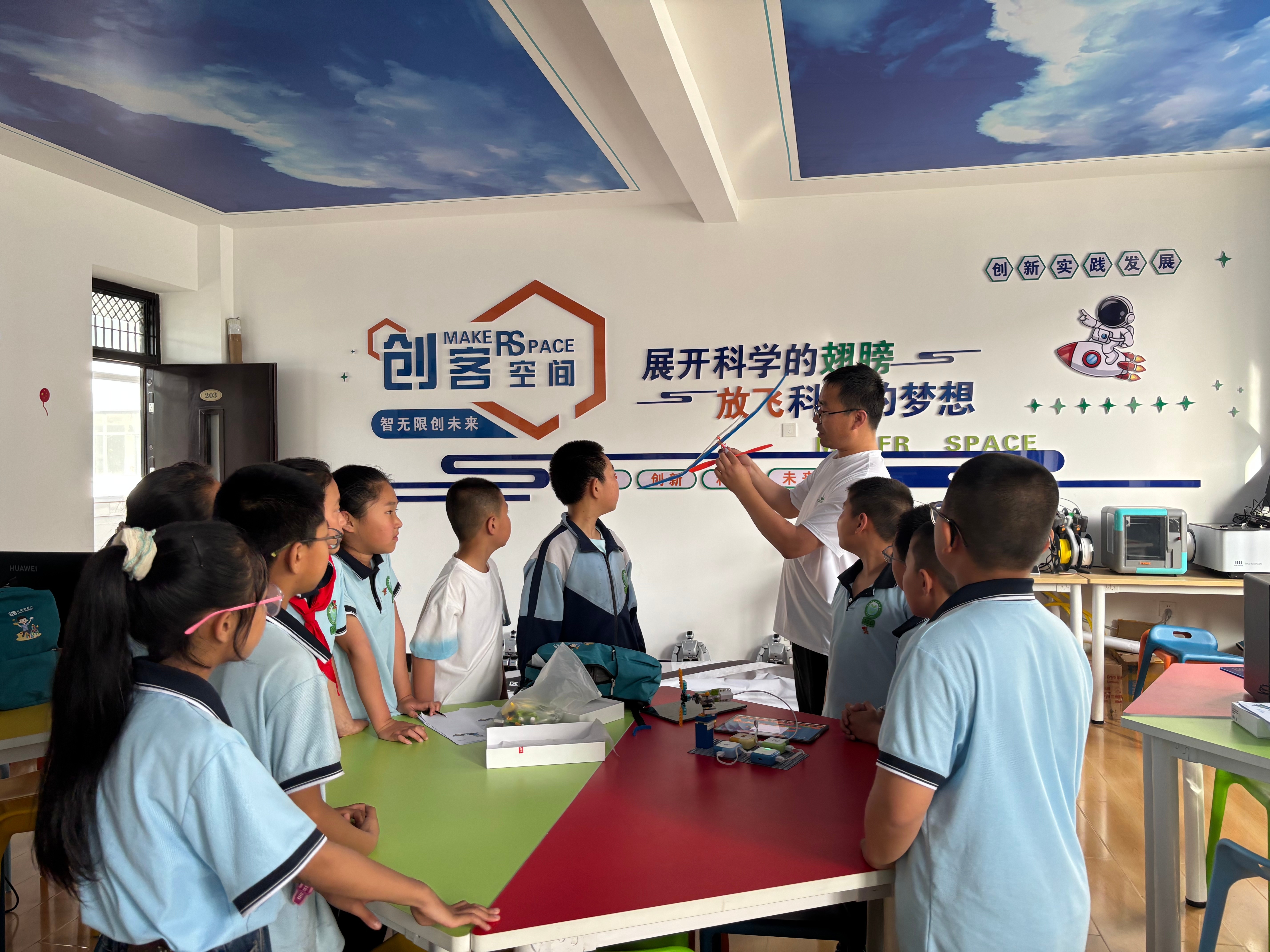 （图片为城南小学科创社团教师给学生讲解飞行原理）