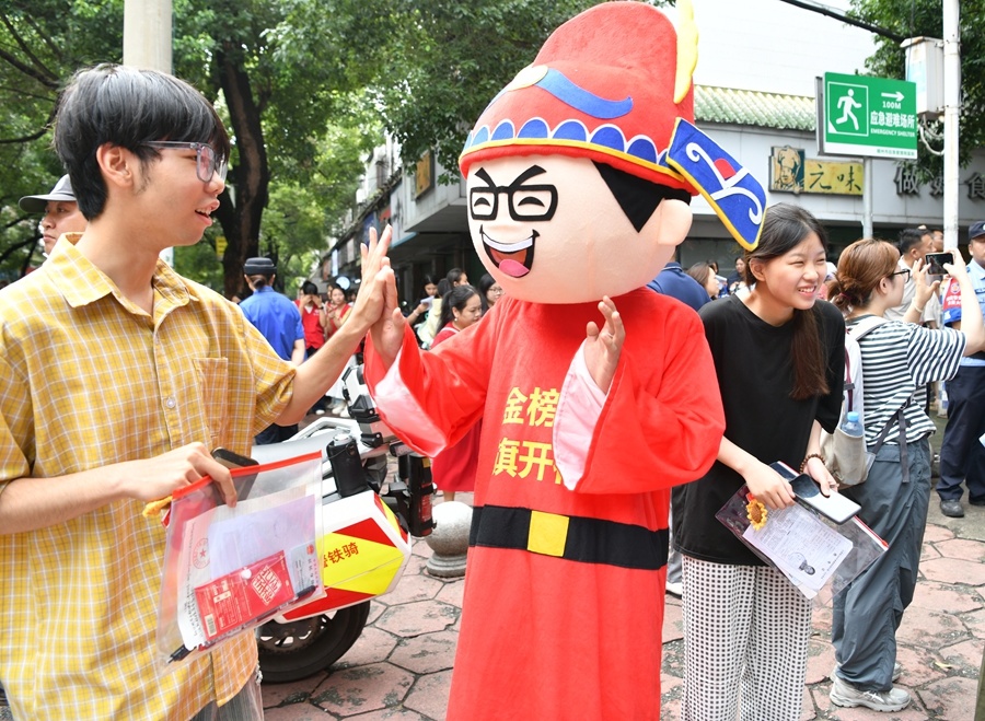 赣州一中考点,志愿者与考生击掌,祝福考生“旗开得胜”。
