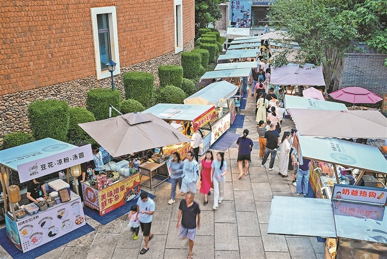 5月29日，游客在小镇市集摊位前挑选心仪物品。