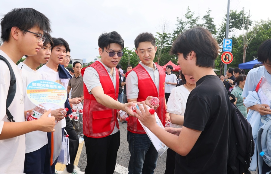 赣州市第十五中学考点外,志愿者们为考生、家长免费发放饮用水、应急物资。