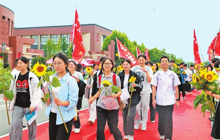 6月7日，在郑州国师实验高中，学生们手持向日葵出发前往考点。记者 张琮 摄