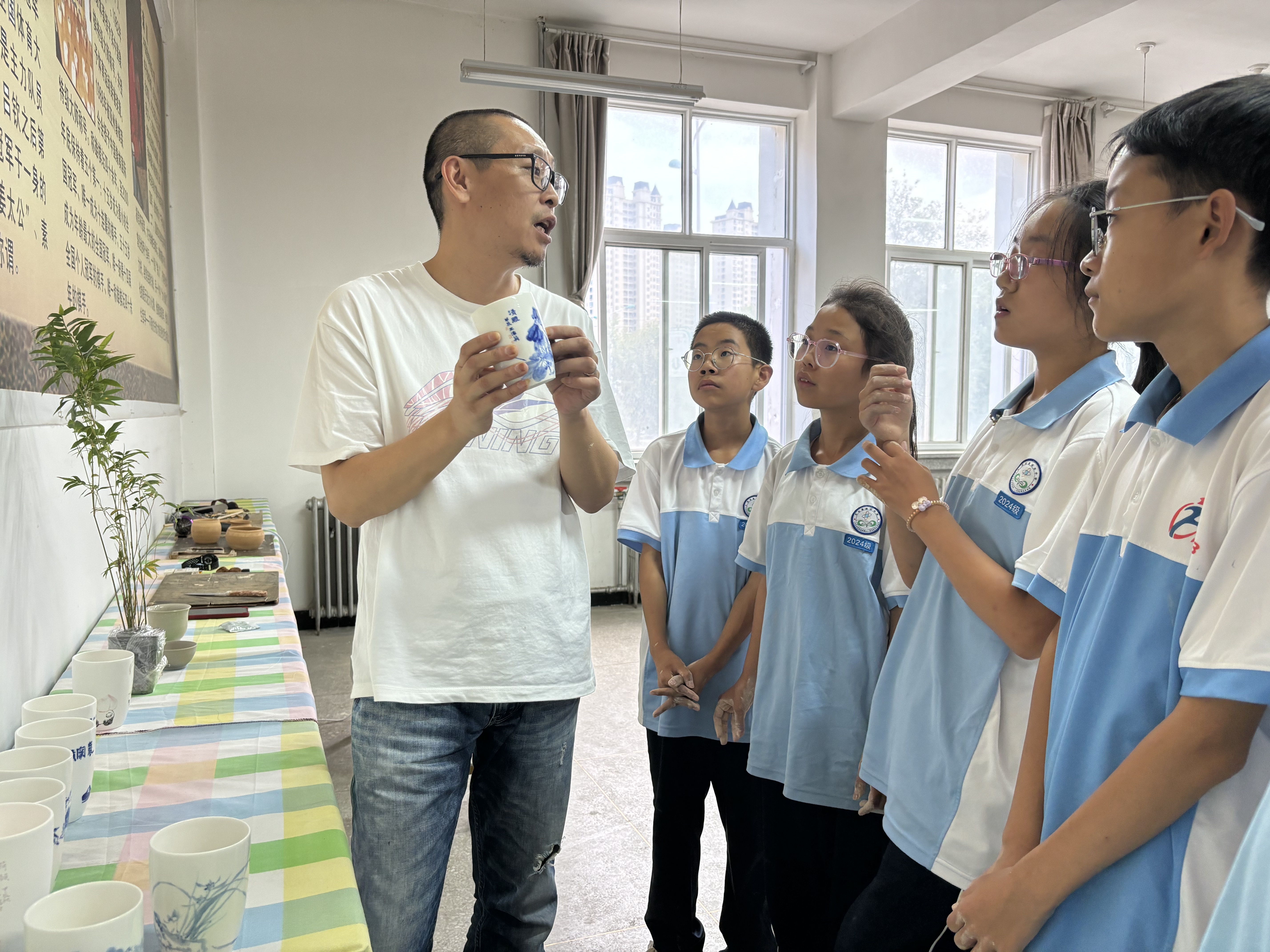 （图片为何玉填给学生讲解陶艺创作的基础技巧）