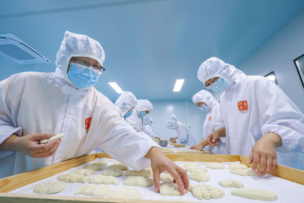 ↑6月6日，在位于河北省沧州市黄骅市的河北帝鉴食品有限公司，工作人员在生产车间制作面花。新华社记者 黄伟 摄