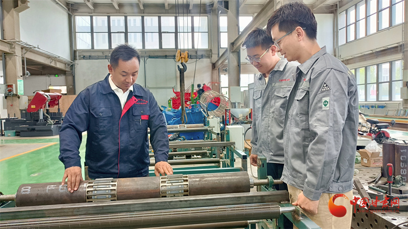 刘小龙和同学们研究农机设备