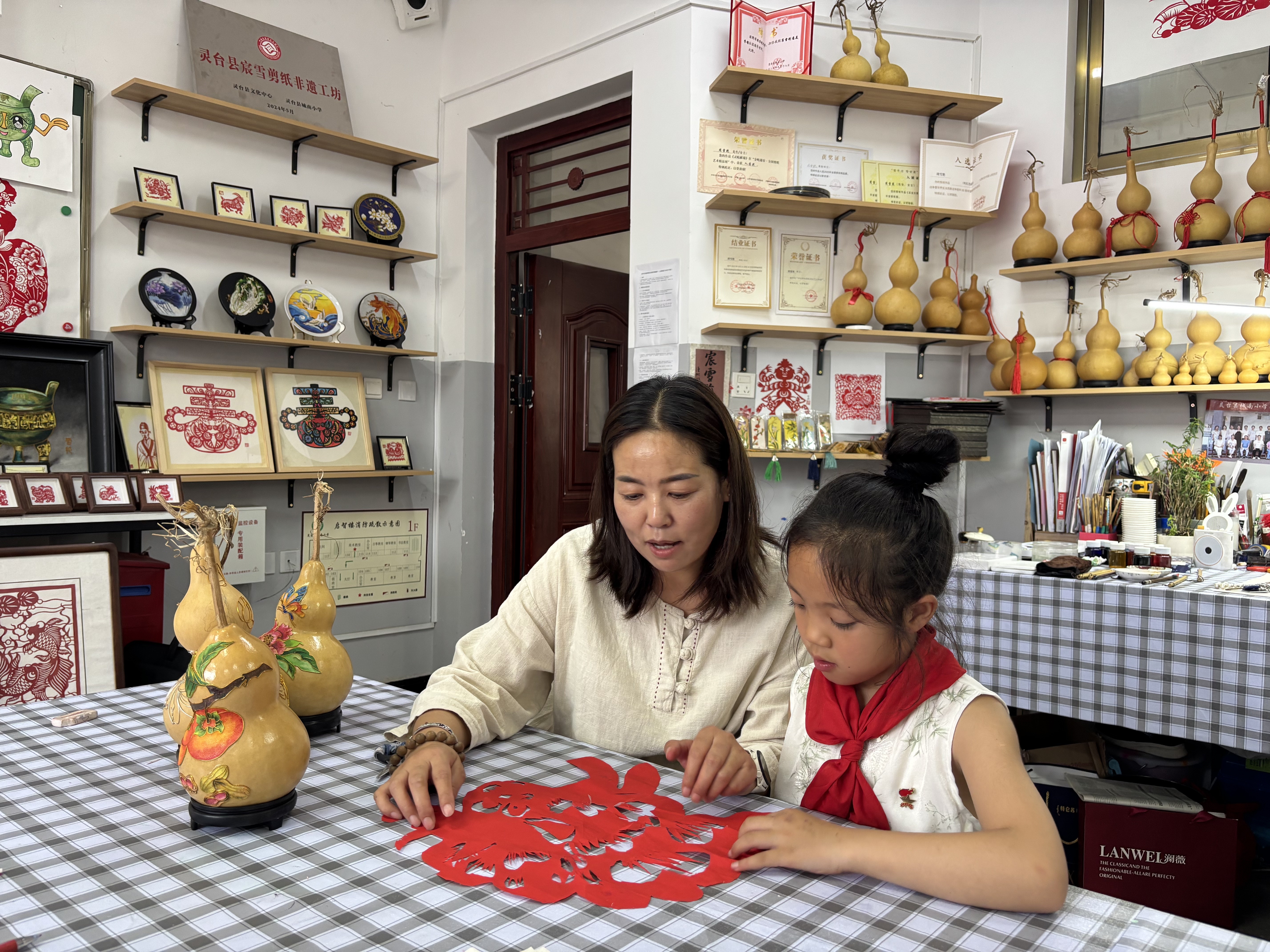（图片为城南小学“宸雪剪纸工坊”美术教师周雪艳指导学生剪纸）