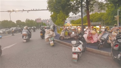 17点30分,玉清路、旺埠路交汇口处青柠市集北门(正门)前道路,违停电动车逐渐增多。
