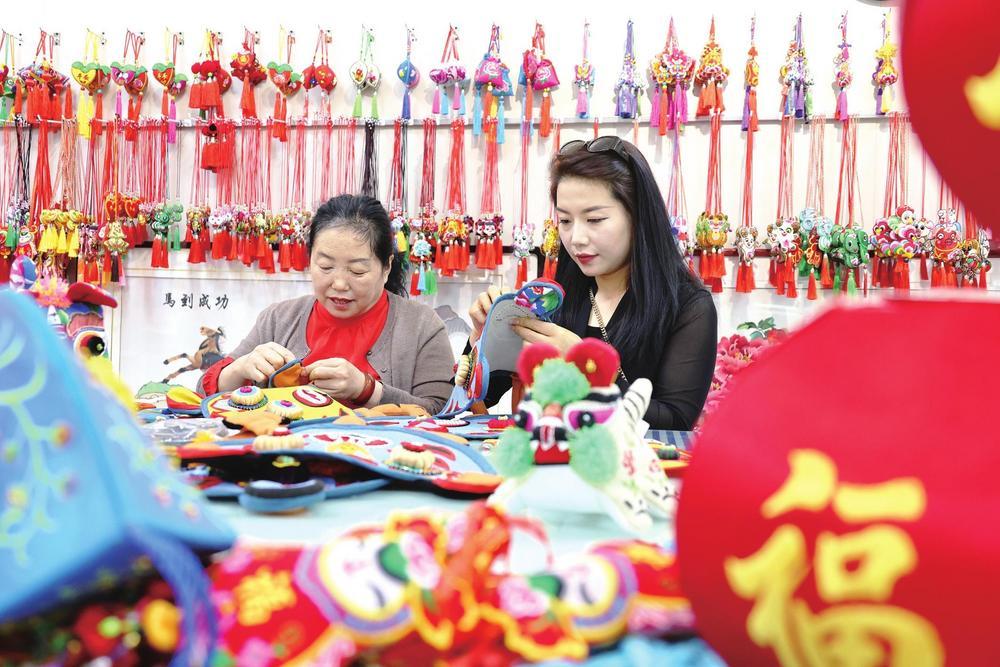庆阳香包绣制市级非物质文化遗产代表性传承人李彩云和女儿绣制香包（西峰区融媒体中心供图）