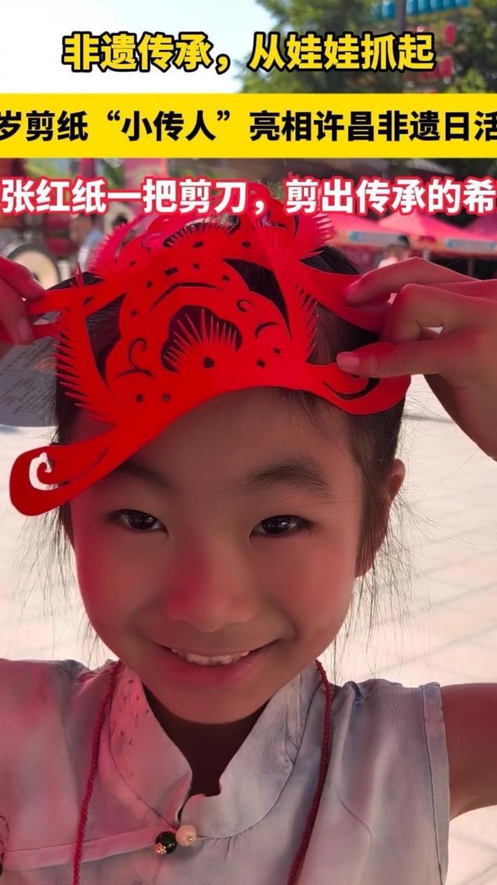 6月13日，2026年许昌市“文化和自然遗产日”活动现场，许昌非遗金氏剪纸传承人金爱霞带着学艺两年的外孙女一起出摊，小姑娘从五岁拿起剪刀，如今已剪得有模有样，引得市民纷纷驻足赞叹。（顶端新闻记者 马涛