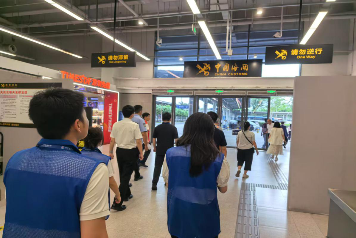 福田公务员服务队在皇岗口岸模拟旅客出入境行走动线提出建议。
