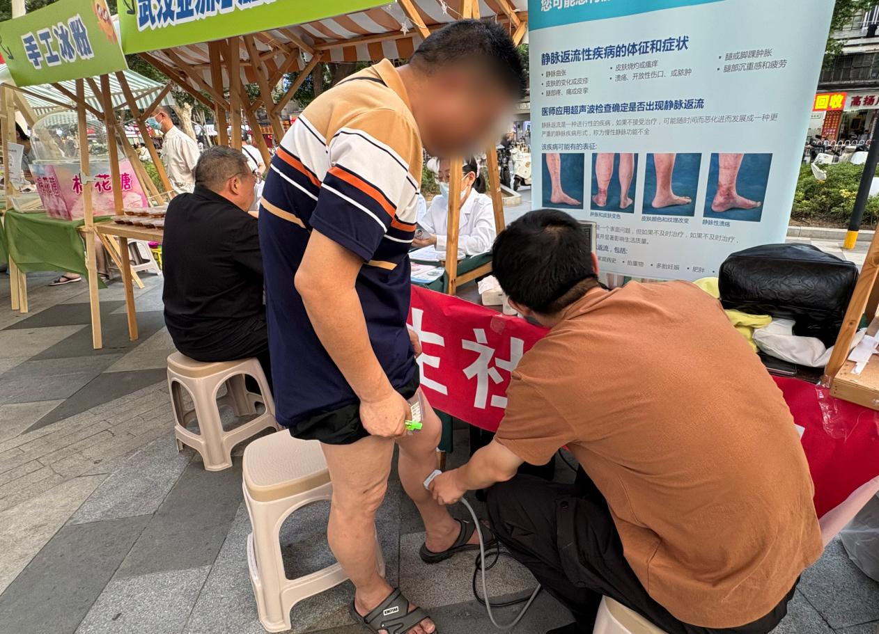 工作人员为居民做静脉曲张初步筛查