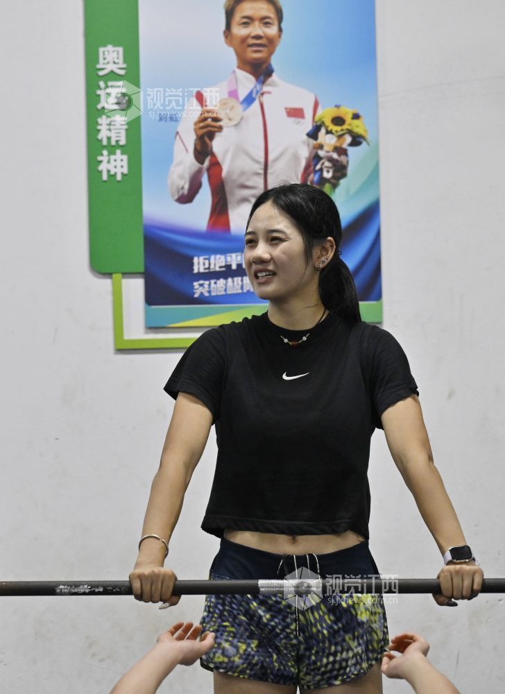 6月5日,江西省奥体中心,张可依辅助队友进行力量训练,墙上贴着江西安福籍奥运冠军刘虹的照片。