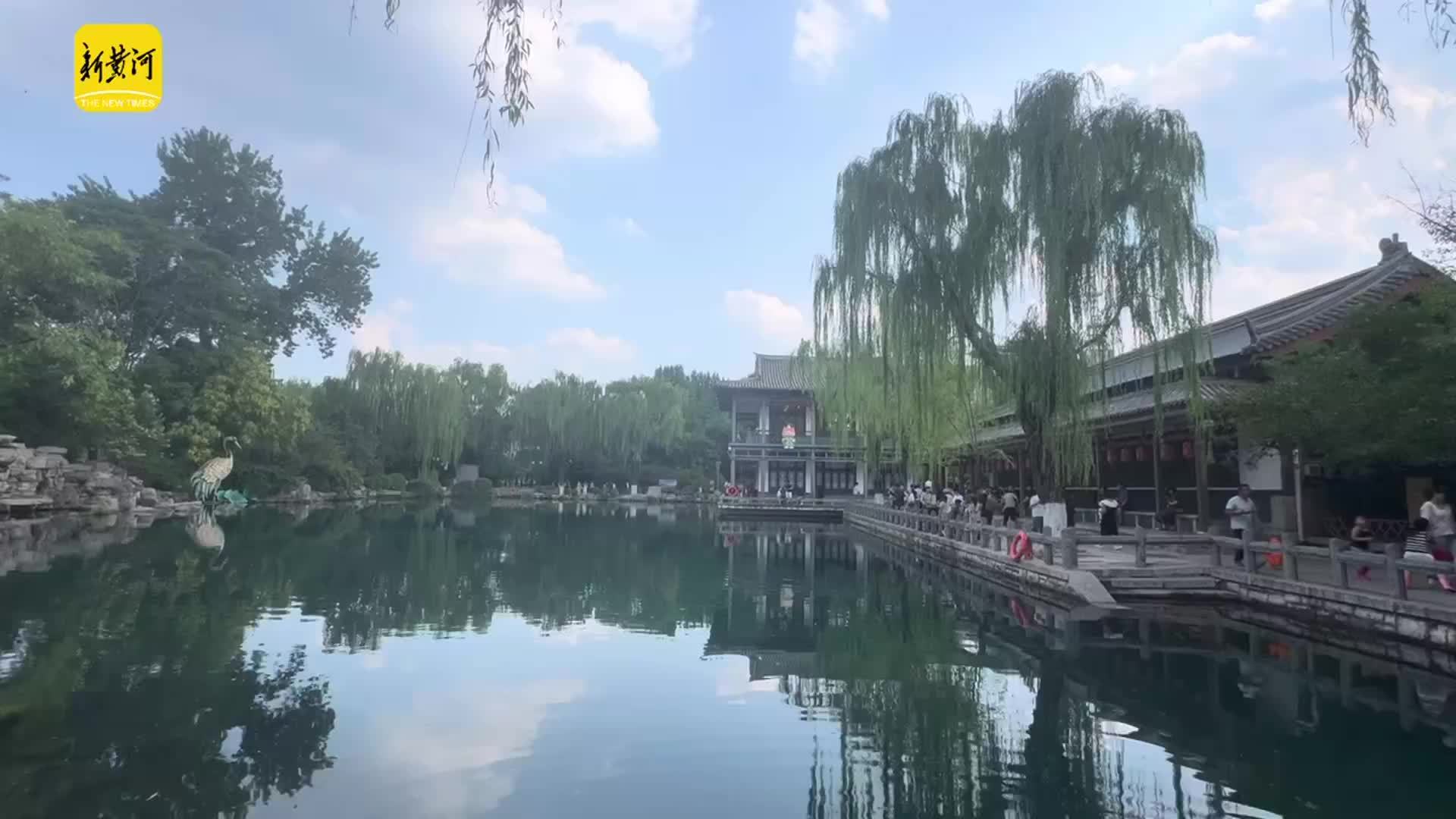 五龙潭公园内澄澈泉池如镜面，蓝天白云倒映成画