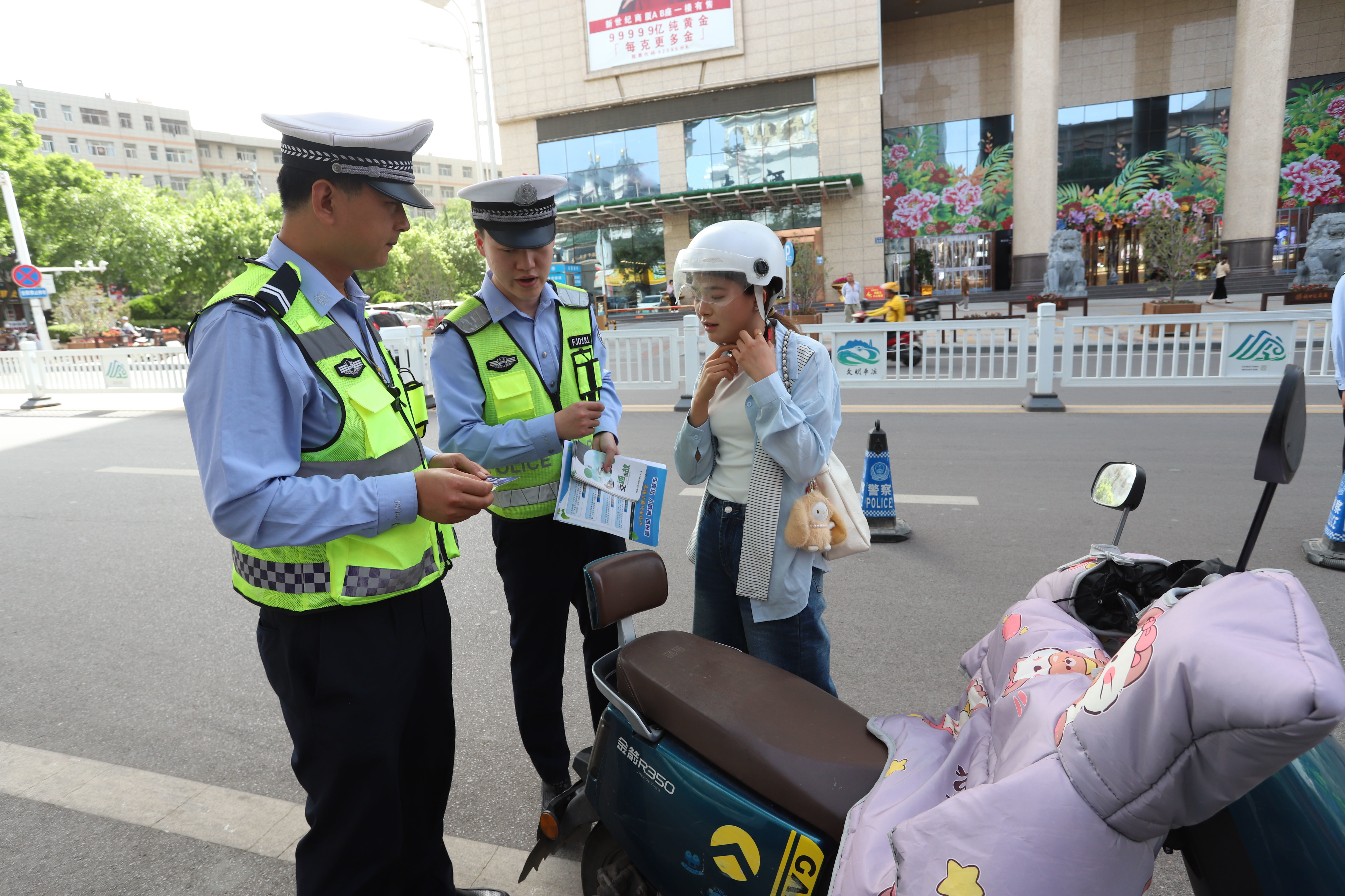 图2为民警辅警给电动车驾驶人员普及交通安全知识(崆峒区融媒体中心供图).jpg