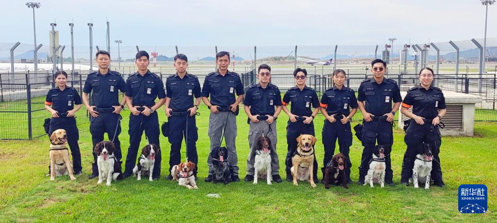 这是机场保安犬只行动小组部分领犬员和犬只合照（6月8日摄）。 新华社发（香港机场管理局供图）