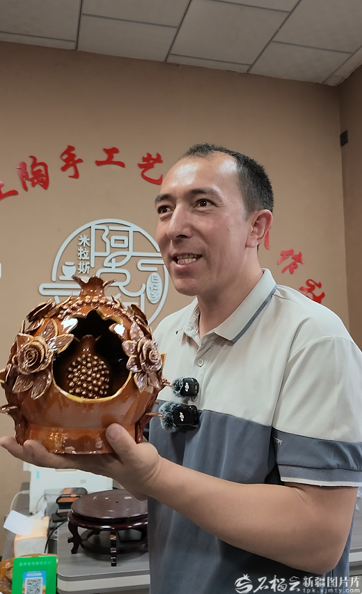 奥布力塔力普&middot;阿吉向采访团展示土陶作品。