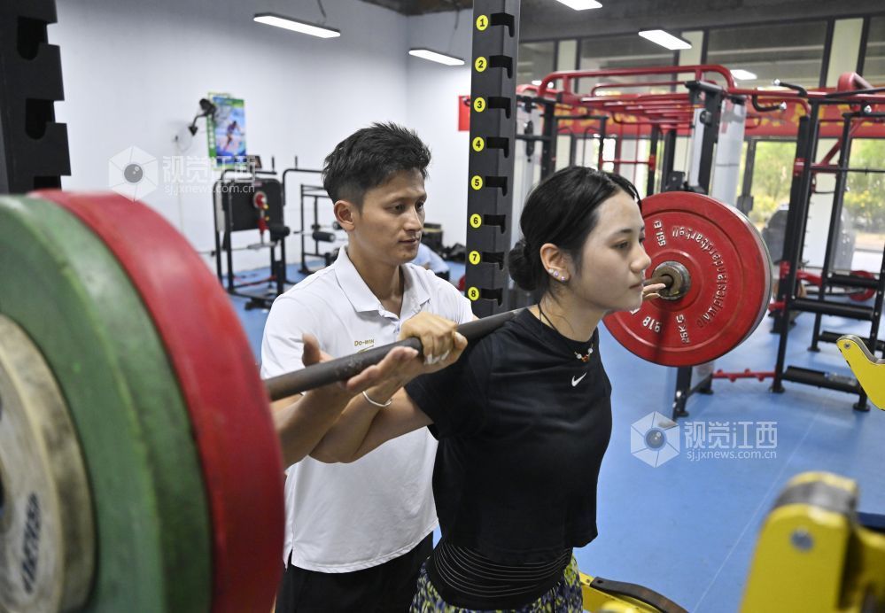6月5日,江西省奥体中心的力量房,教练罗建辅助张可依进行力量训练。