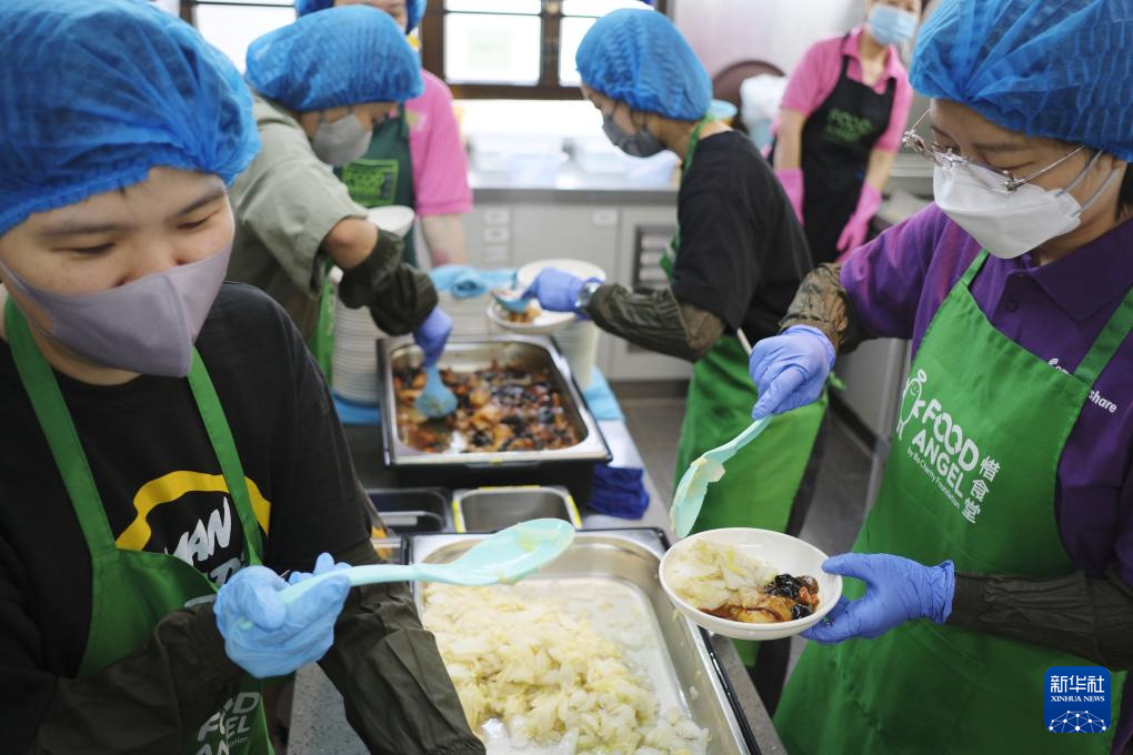 在香港深水埗的惜食堂社区中心，义工在帮助分发饭菜（5月7日摄）。新华社发（王申 摄）