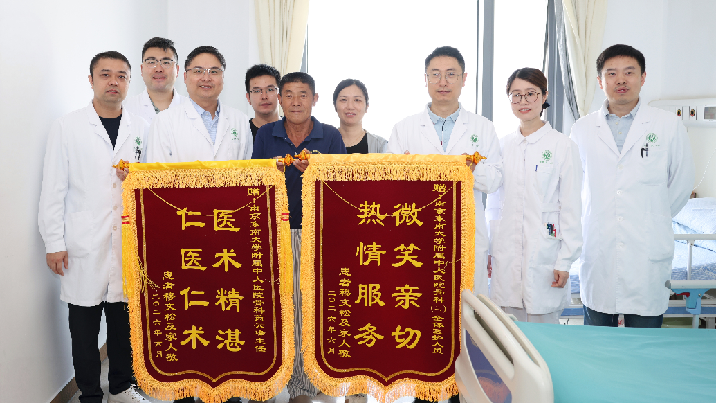 患者老穆向芮云峰教授(左三)医护团队赠送锦旗 王倩摄