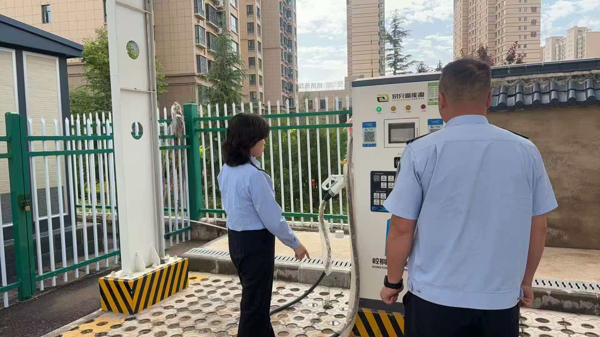 图为执法人员检查充电桩运行情况.jpg
