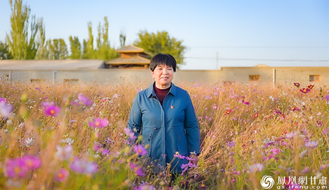 甘肃省玉门市柳河镇红旗村党支部书记顾红艳站在村里的初心花园,讲述父亲顾天祥治沙的故事。张修毅 摄