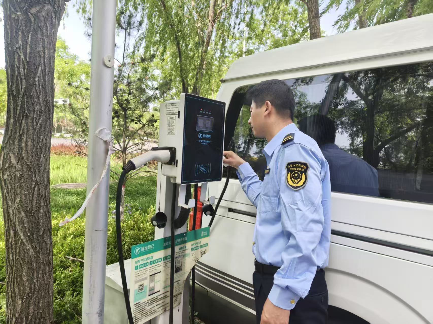 图为执法人员实地检查充电桩操作流程.jpg