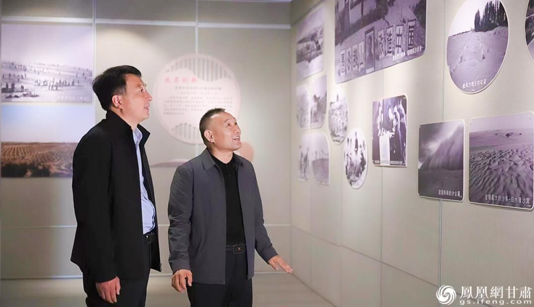 金塔县潮湖林场党支部书记达军山（右）讲述林场植树造林的历史　张修毅　摄