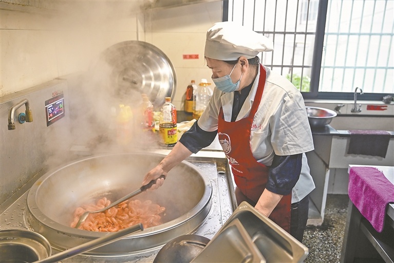 食堂工作人员正在为学生准备午餐。