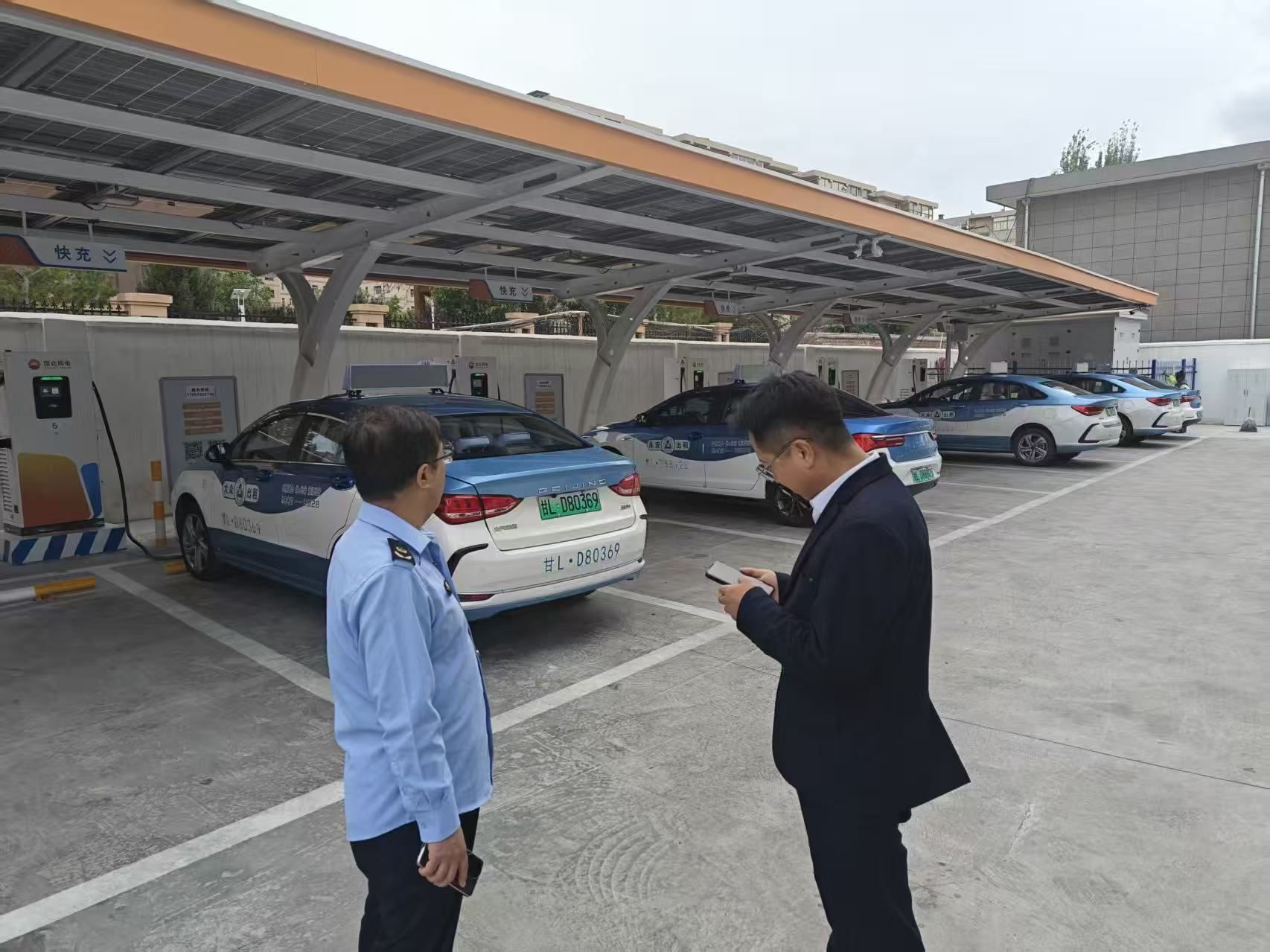 图为执法人员检查充电桩工作状态.jpg