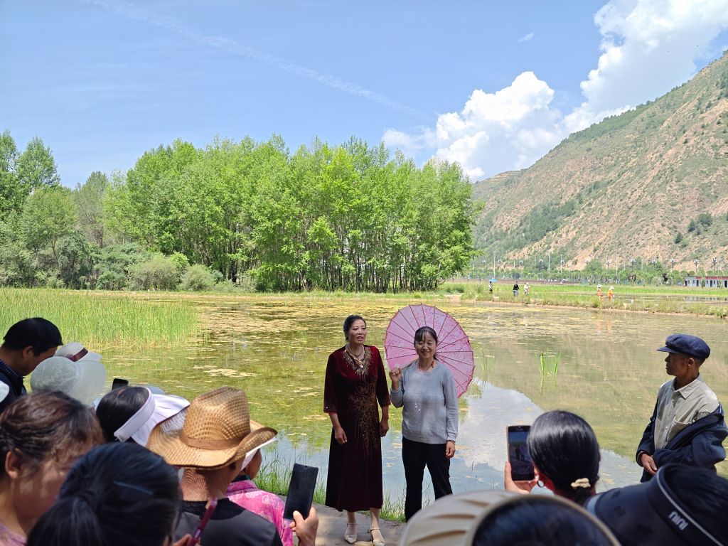 6月30日，“洮岷花儿”代表性传承人包小菊（右）在一处树荫下清唱“花儿”。新华社记者　郎兵兵　摄