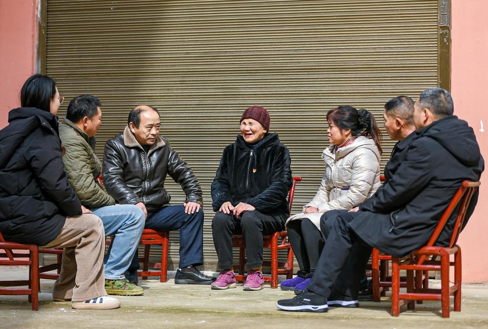 刘孝英老人给街坊邻里宣讲党的惠民政策。