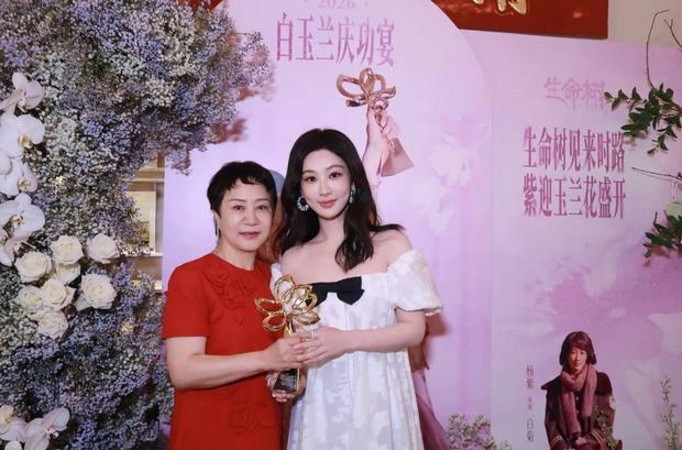 杨紫母亲一身素衣温婉柔和，眼神满是对女儿的珍视。