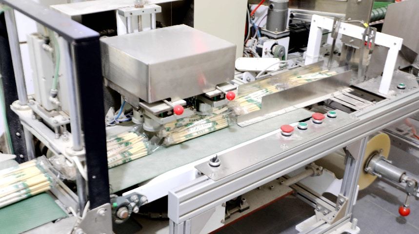 在加工车间内，自动化生产线全速运转，一根根毛竹经过切割、打磨、成型等多道工序，快速变身规整洁净的一次性竹筷