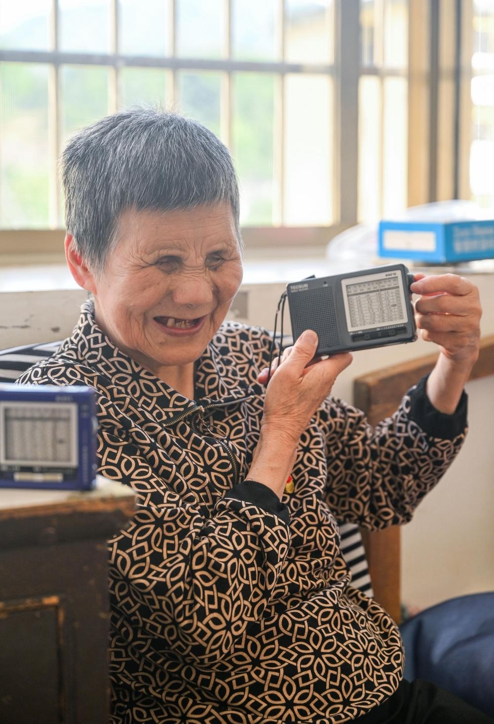 刘孝英老人正在调试日常陪伴她的收音机。