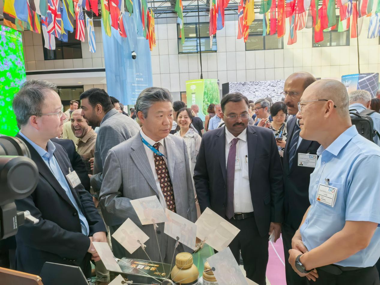 图3：中国驻联合国粮农机构代表张陆彪大使（左二）在金丰公社展位指导交流