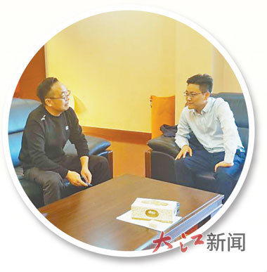 吕鹏(右)与企业家交谈。