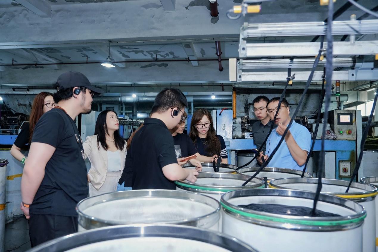 图：浙江金帆纺织有限公司工厂长王建宝（右一）带美的工业之旅参访团实地参观产线