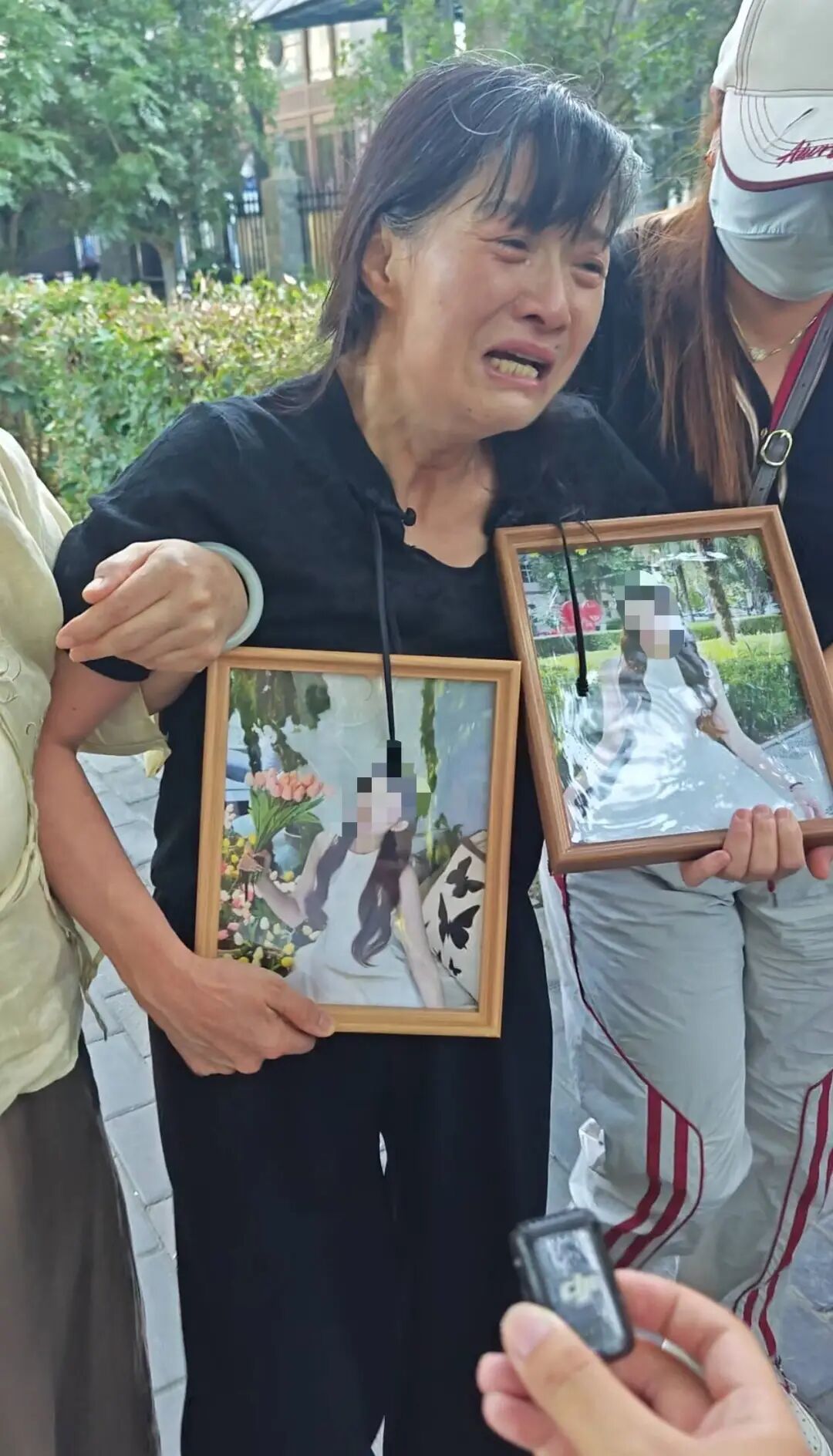 强女士出庭后抱着女儿照片痛哭（极目新闻记者现场拍摄）