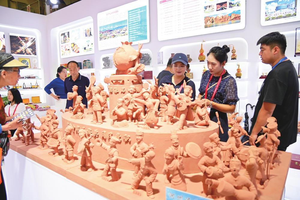 临夏展馆展出的非遗河州泥塑《五十六个民族一家亲》人物栩栩如生,引得宾客驻足观赏。