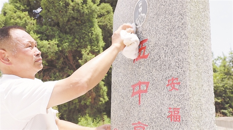 肖树初擦拭伍中豪烈士墓墓碑。