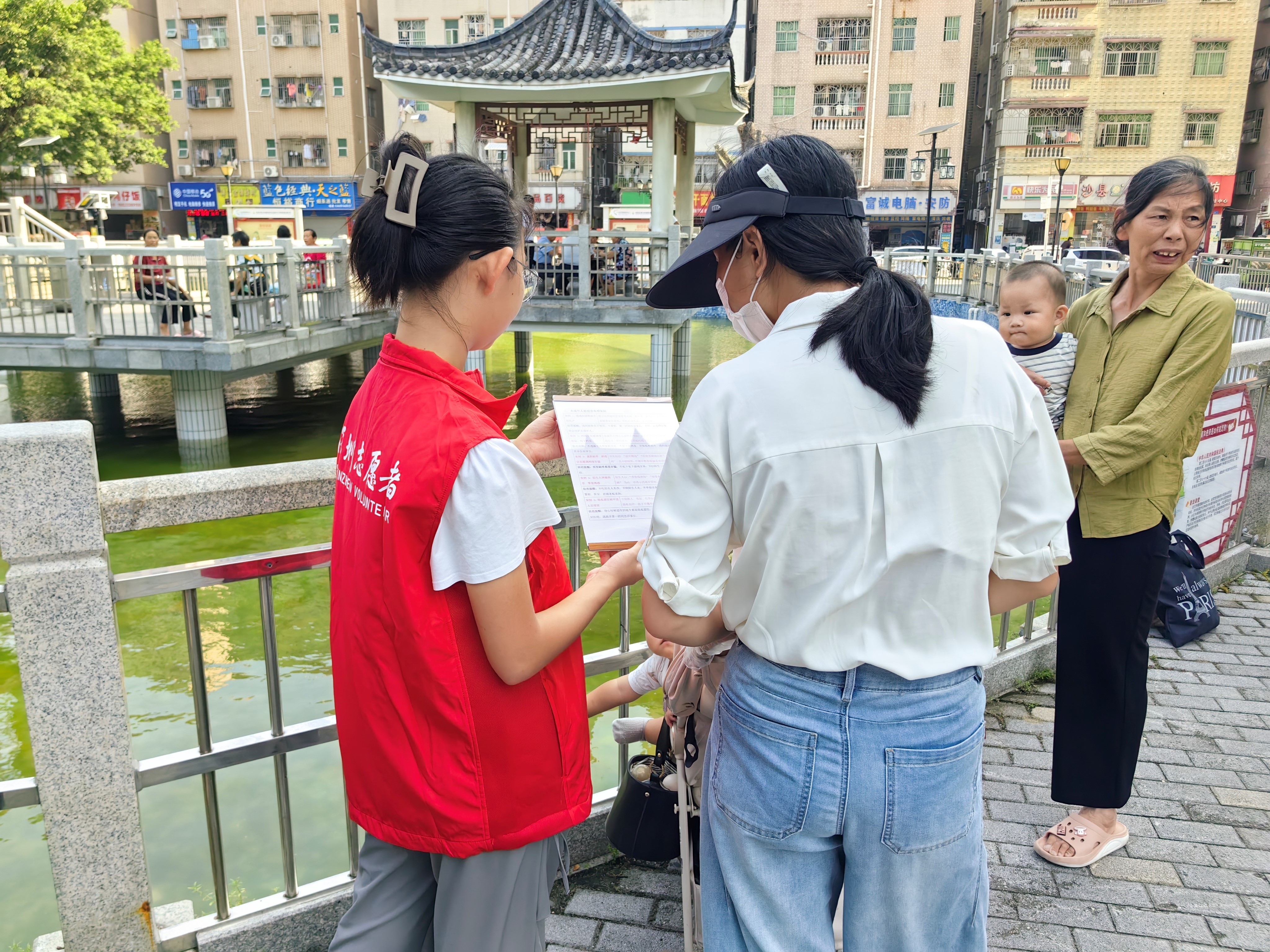志愿者向居民介绍未成年人被侵害典型案例