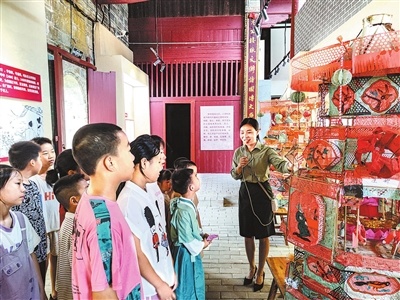 宁都县东山坝镇小源村村史馆内，讲解员为青少年介绍客家民俗文化“扛灯”。彭歆冉 摄