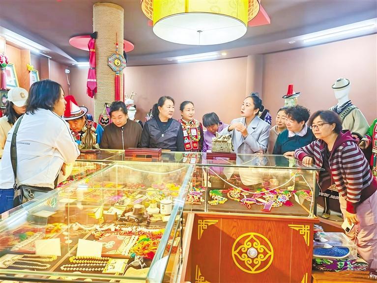 杨海燕（右四）向参观者介绍刺绣产品