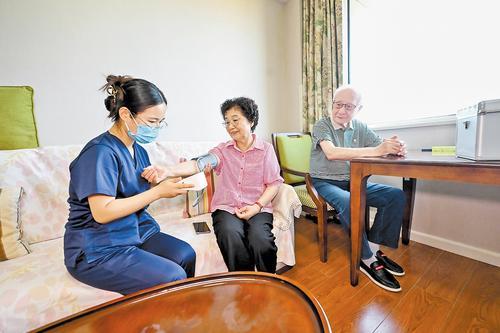 7月15日,香河大爱书院养老中心,医护人员在为老人测量血压。截至目前,该中心已入住老人700余位,其中京津老人占比达95%。本报记者 田明摄
